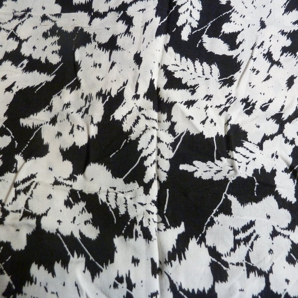 Fabric with white flower and fern pattern on a black background